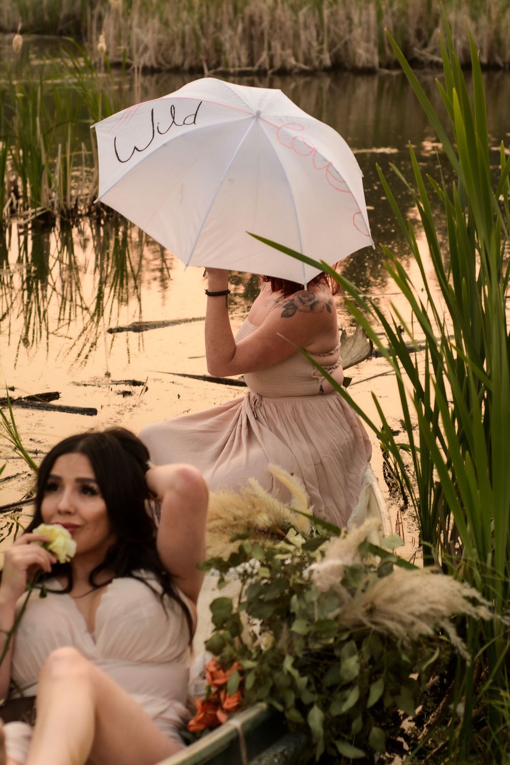 A series of artistic photographs shows figures with white parasols posing near a pond with reeds and greenery.