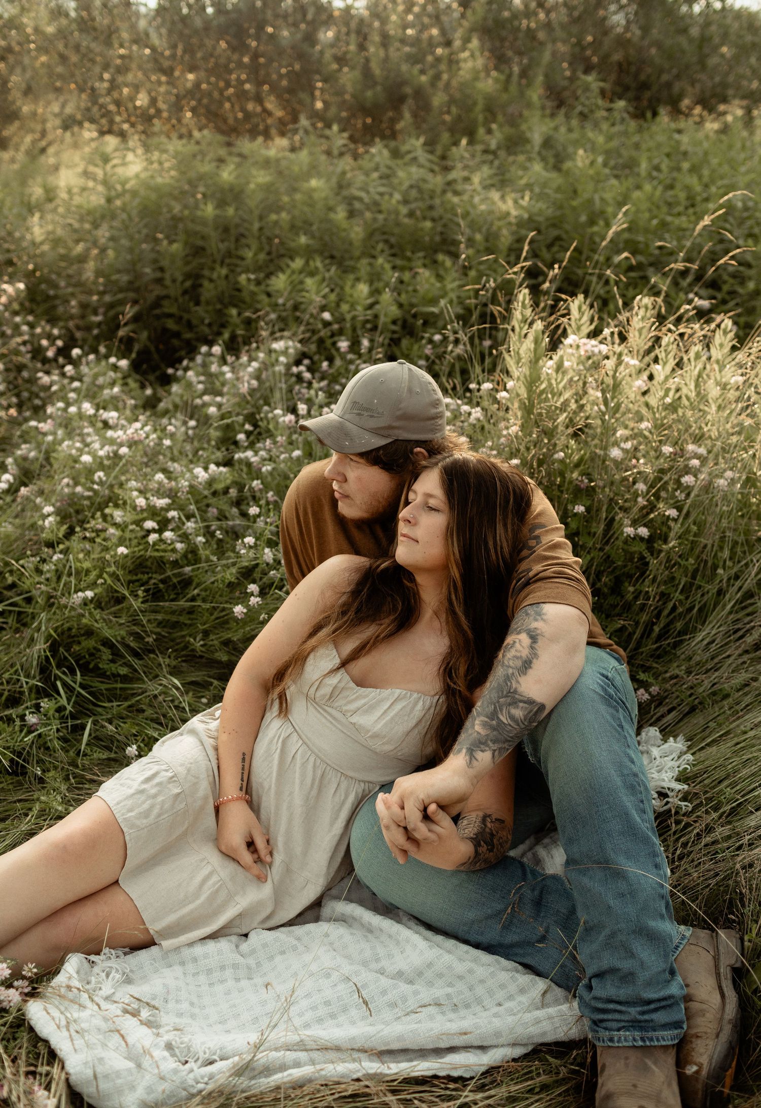 Couple sharing a joyful embrace during golden hour in casual fall attire.
