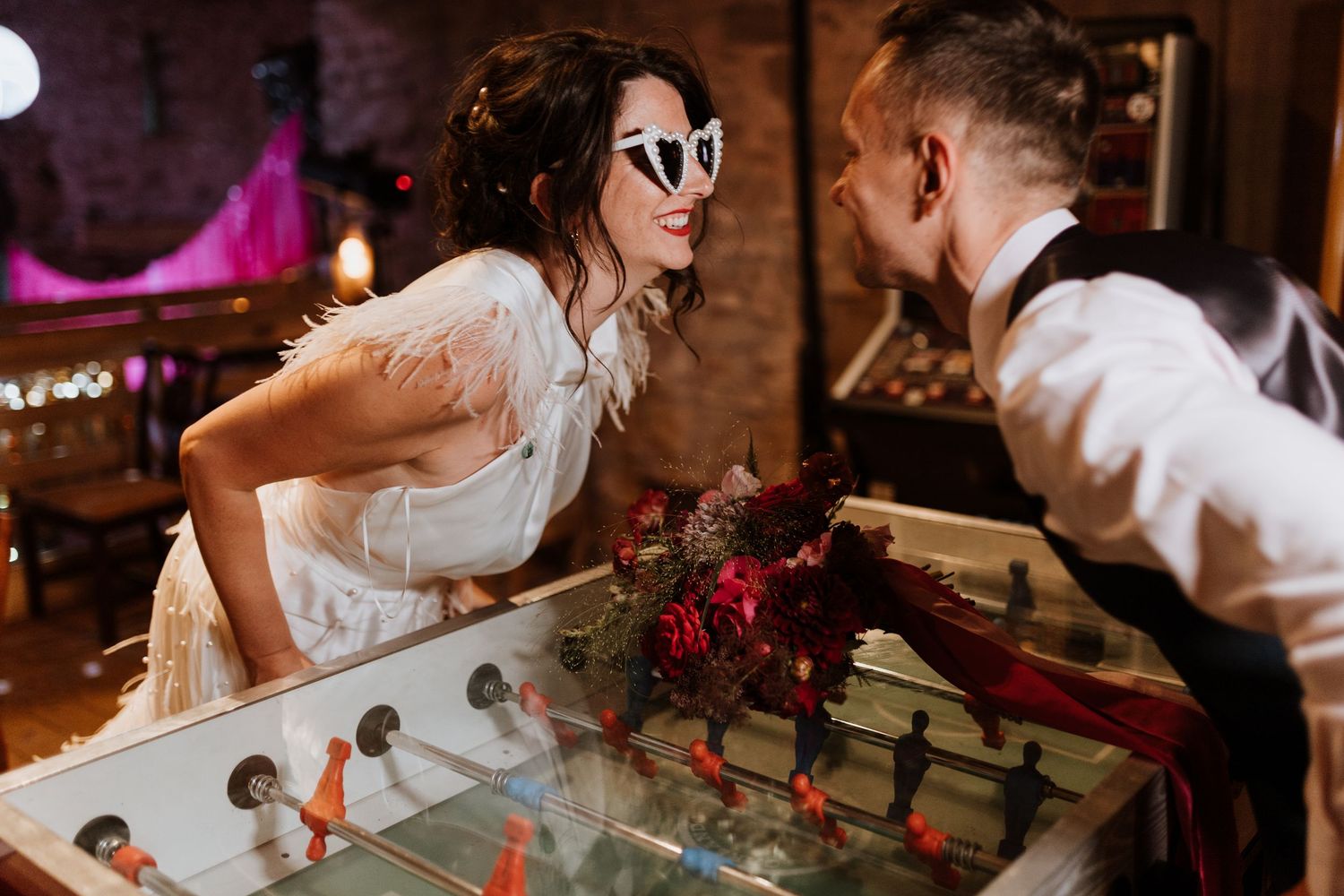 Newly married couple plays foosball at Lyde Court in the games room