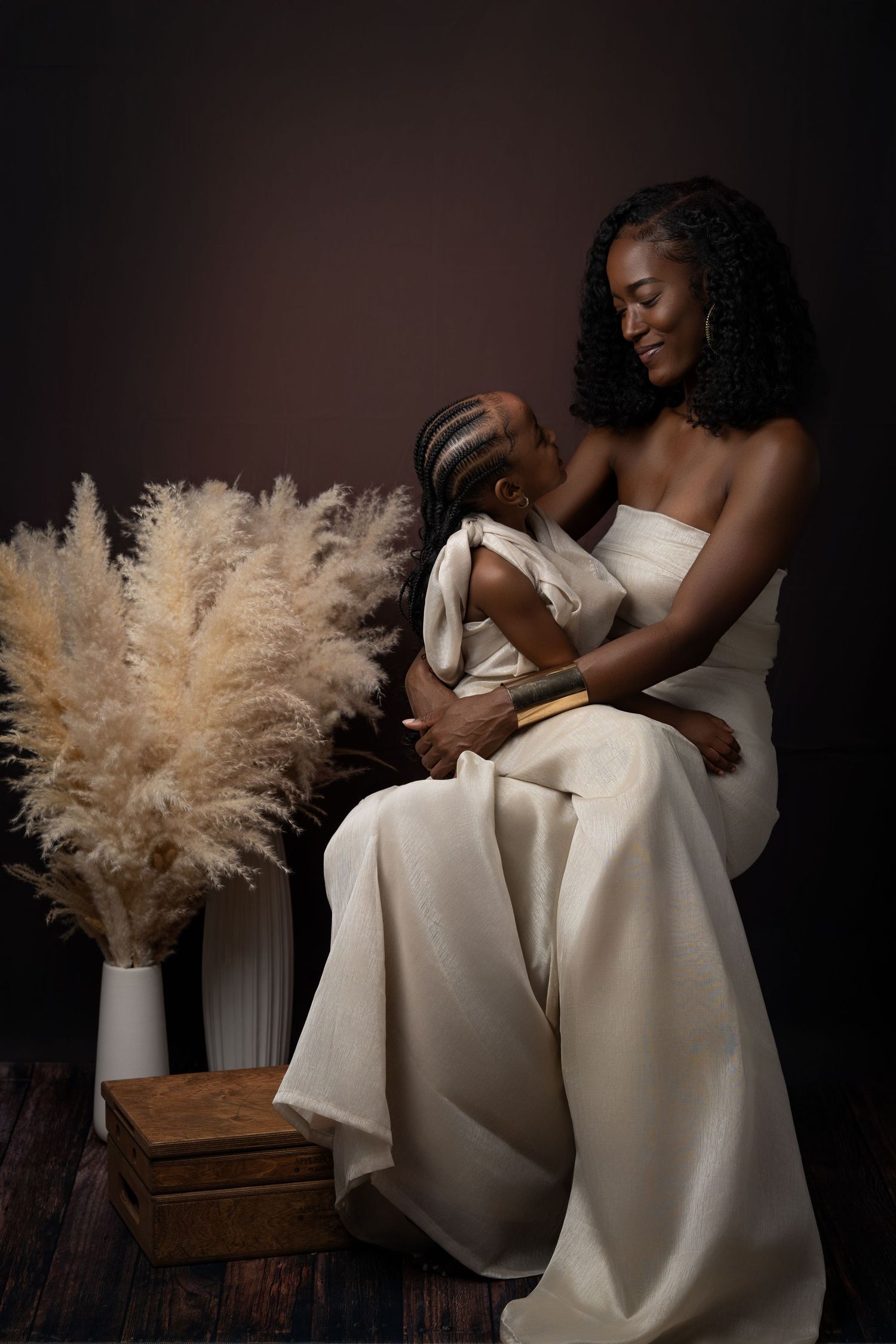 A series of artistic portrait photographs featuring a figure in a flowing white dress with pampas grass decorative elements.