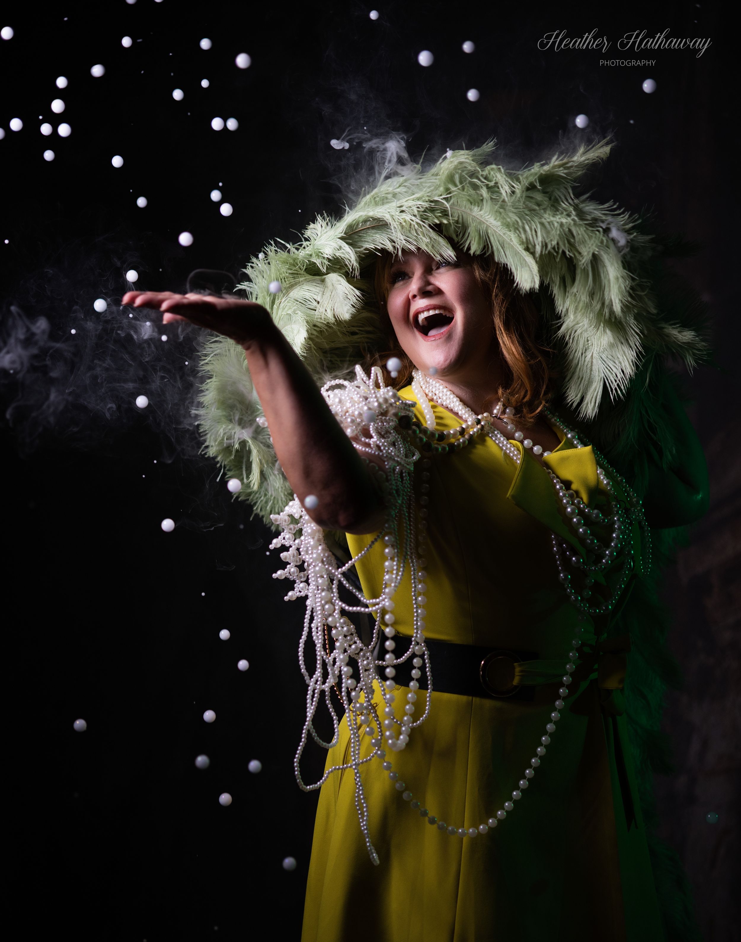 A performer in a yellow dress and feathered headpiece sings passionately against a dark starry background.