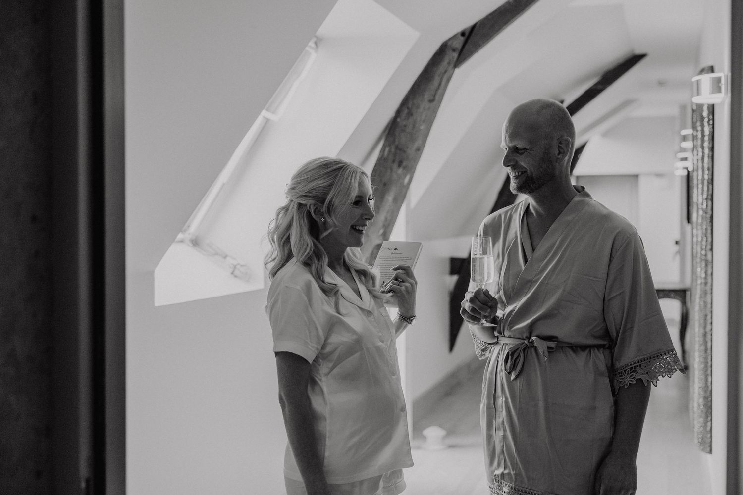 Two people having an animated conversation in a bright hospital hallway in black and white.