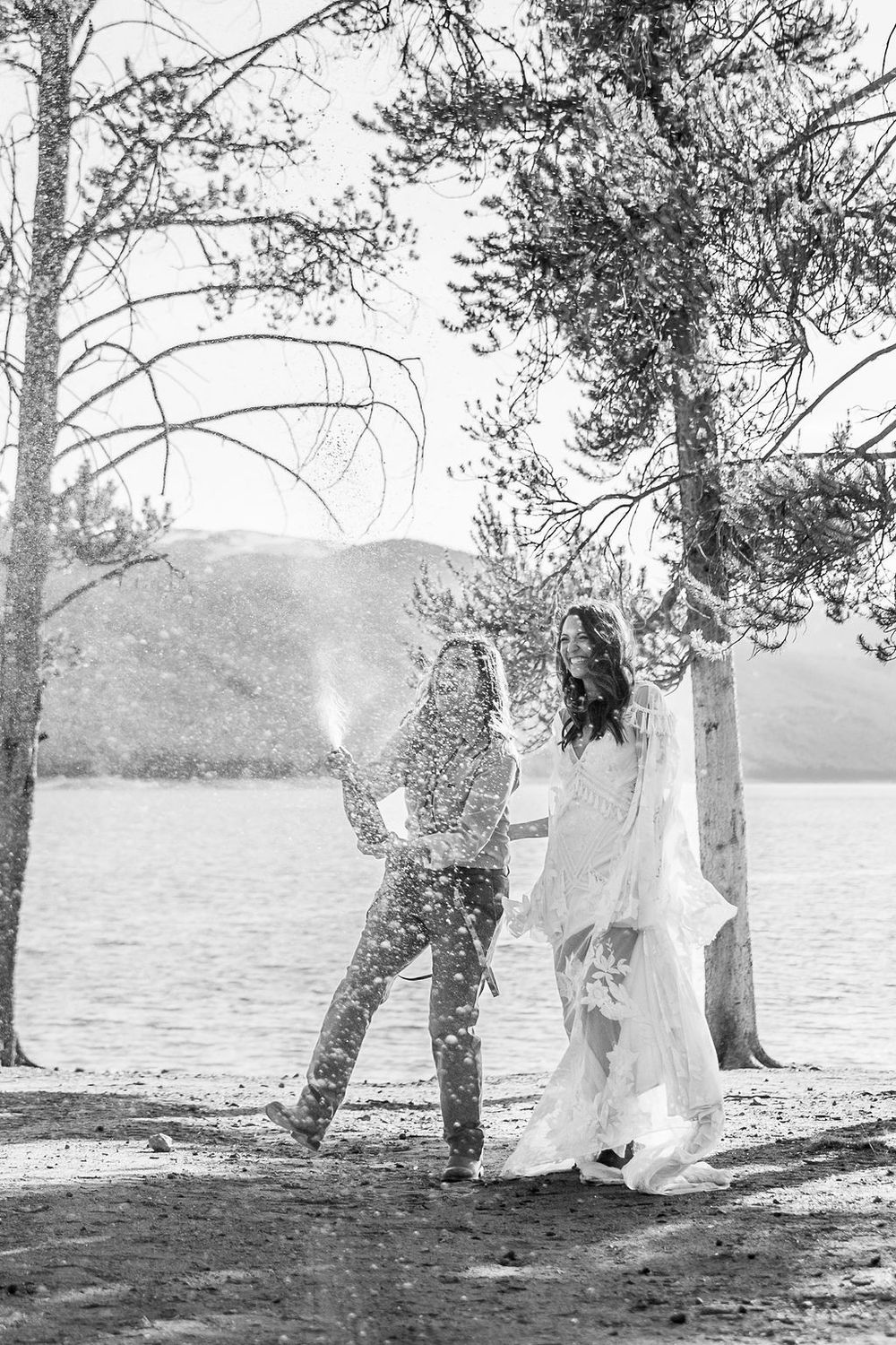 A black and white sequence of artistic photographs showing flowing white fabric draped between trees near a serene lake.