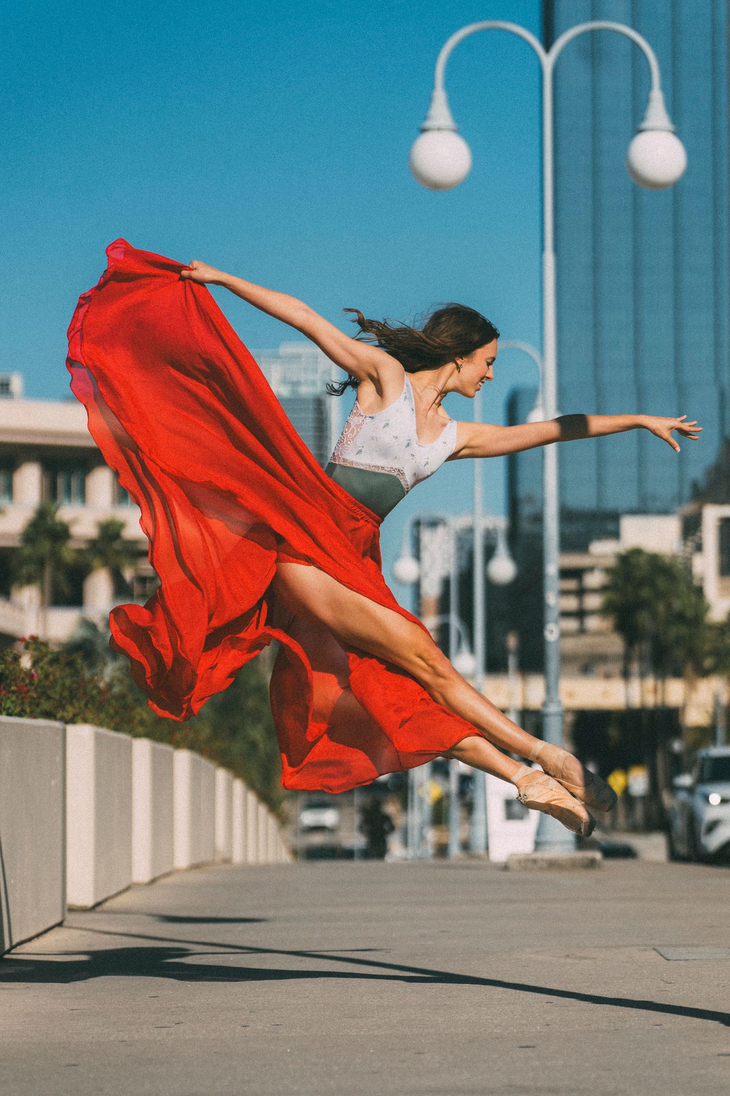 Tampa Ballet Dance Photography of a ballerina leaping in the air with a vibrant red skirt flowing in the air