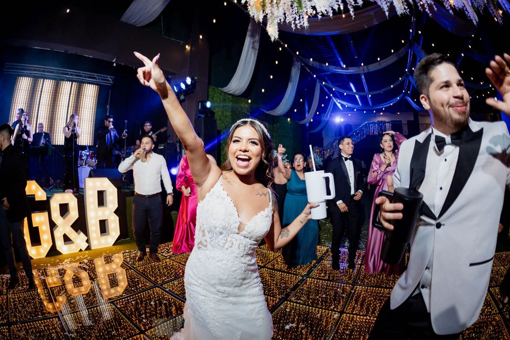 Joyful celebration on dance floor with decorative gold letters and lighting effects.