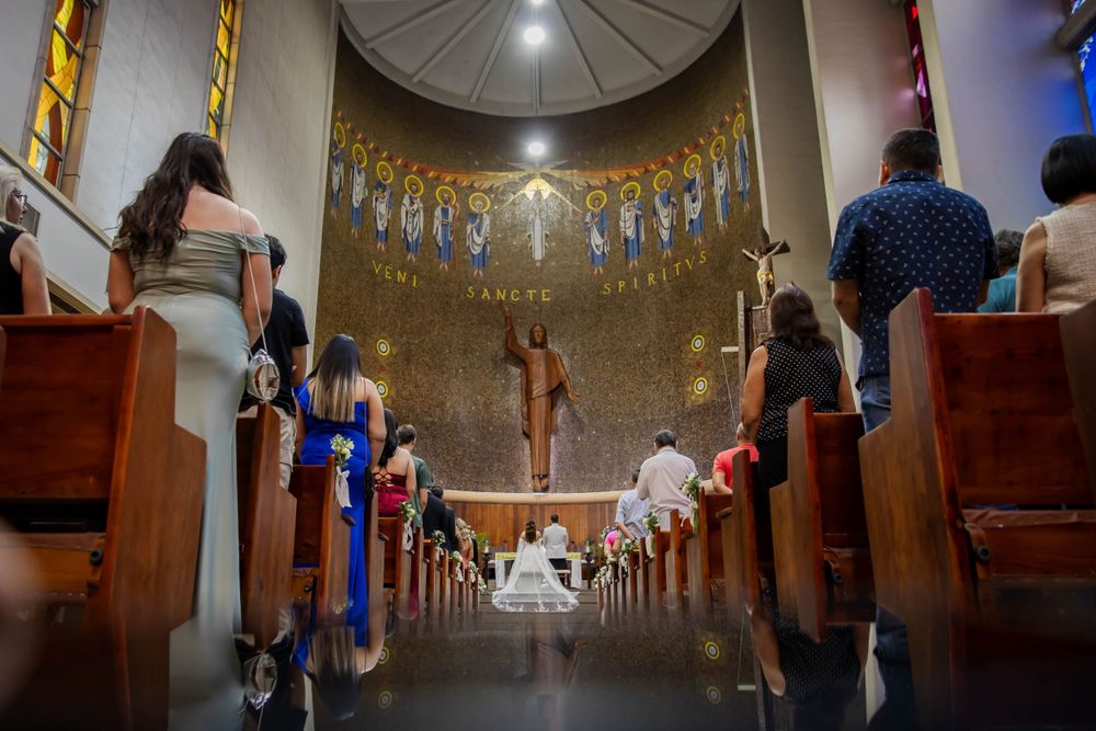 Wedding ceremony in church with dramatic wide angle view down center aisle.
