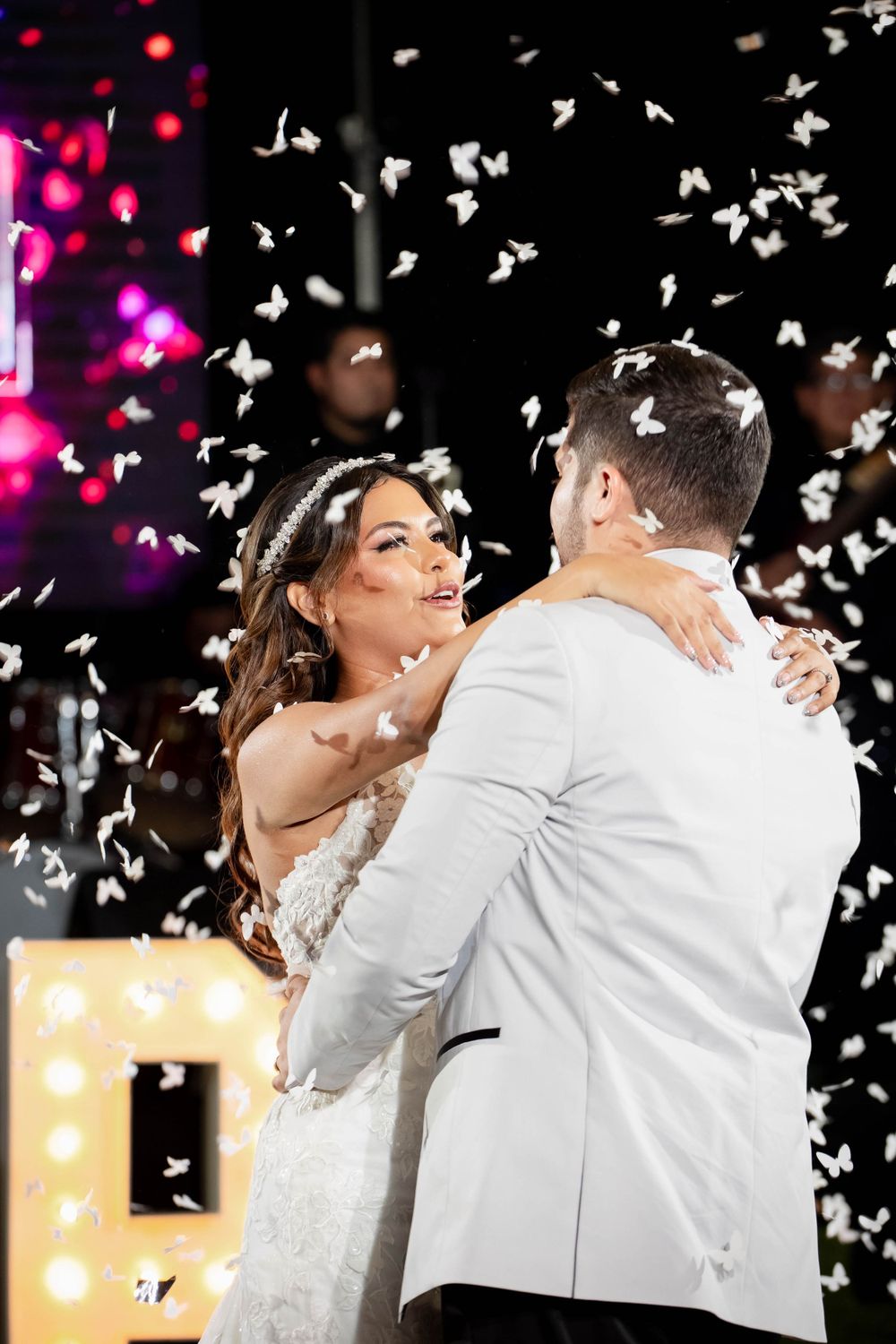 Romantic dance moment with confetti falling during wedding reception.