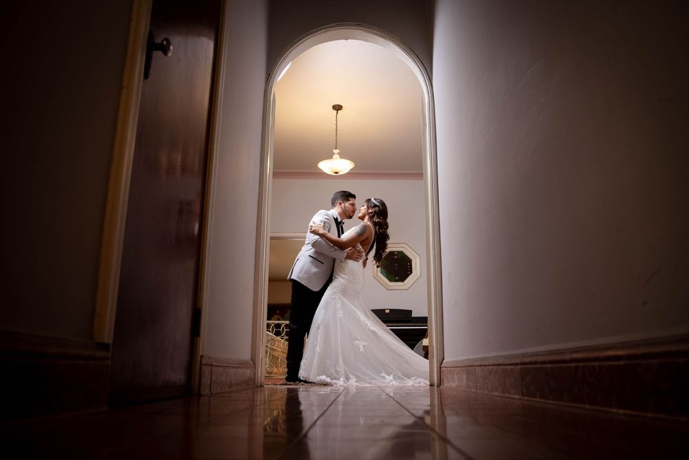 Romantic archway silhouette of wedding couple in dramatic lighting.
