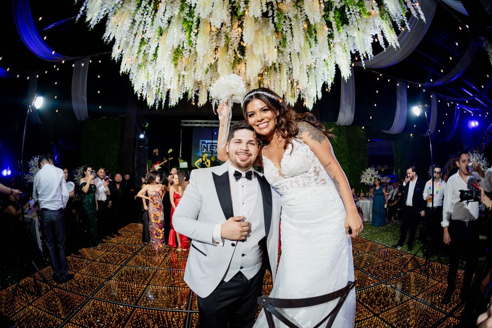 Wedding celebration under an elaborate floral chandelier installation with party lighting.