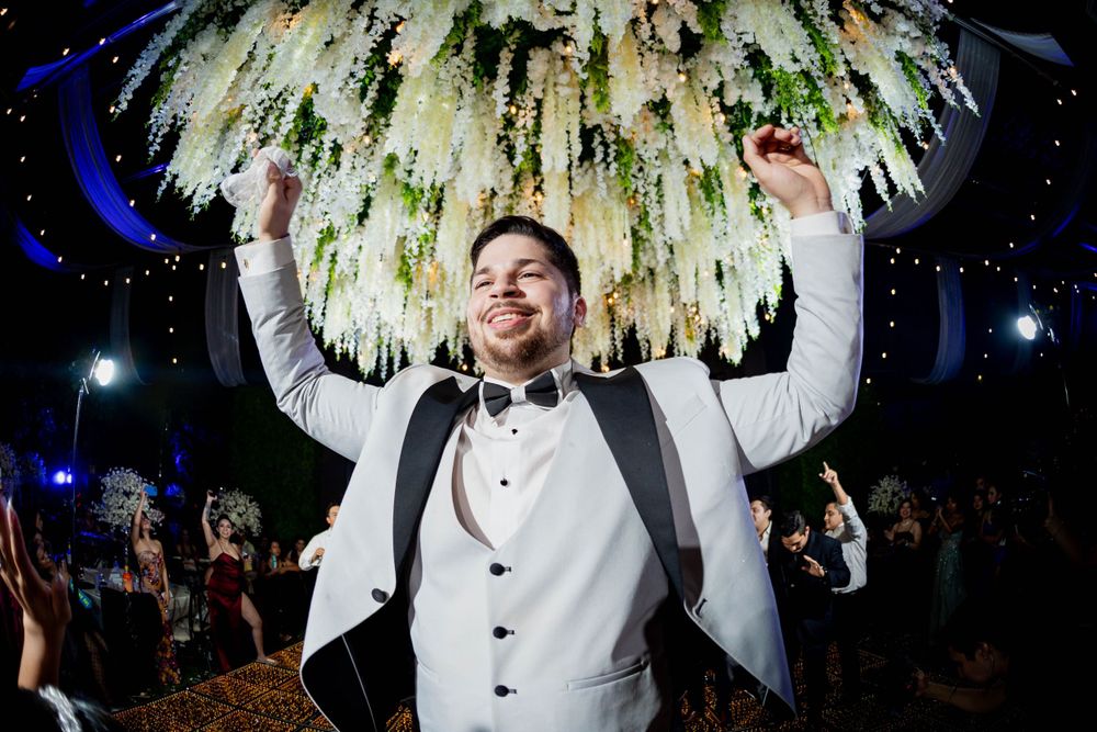 Celebration under dramatic floral chandelier with party lighting and decor.