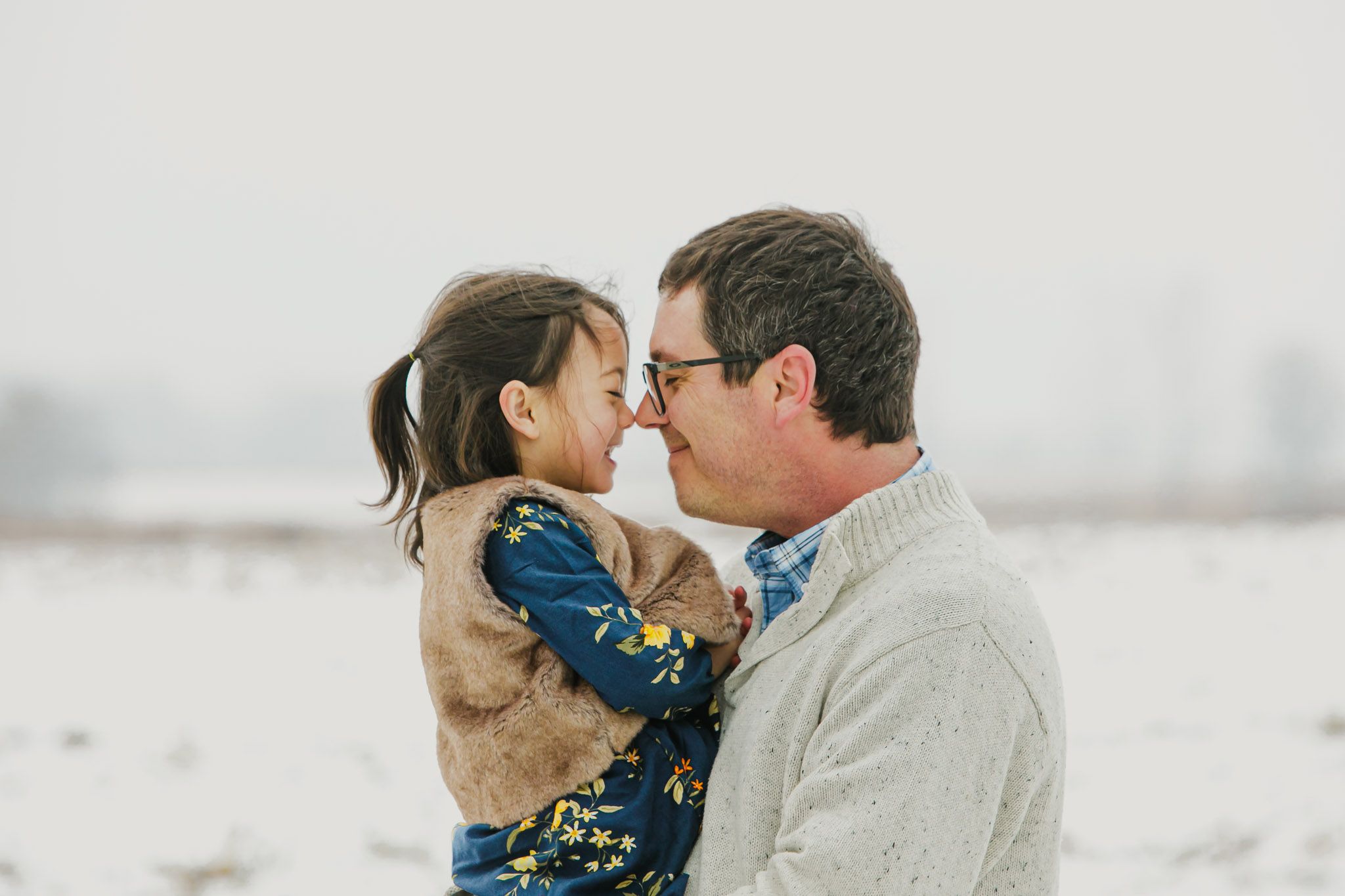 Close intimate moment between two people sharing an embrace in a snowy winter landscape.
