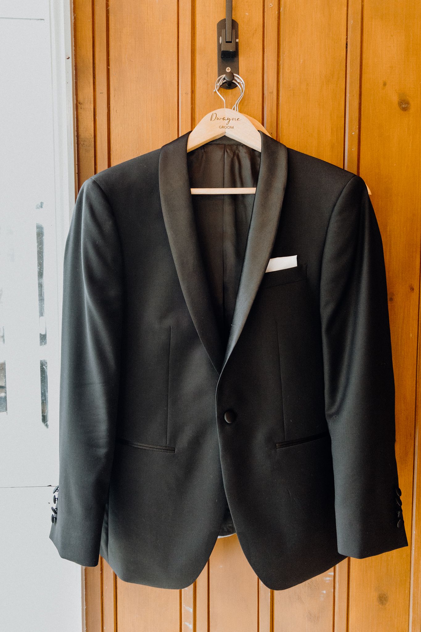 Black formal tuxedo jacket with satin lapels and white pocket square captured by Apertured Media Auckland Wedding Photographer.