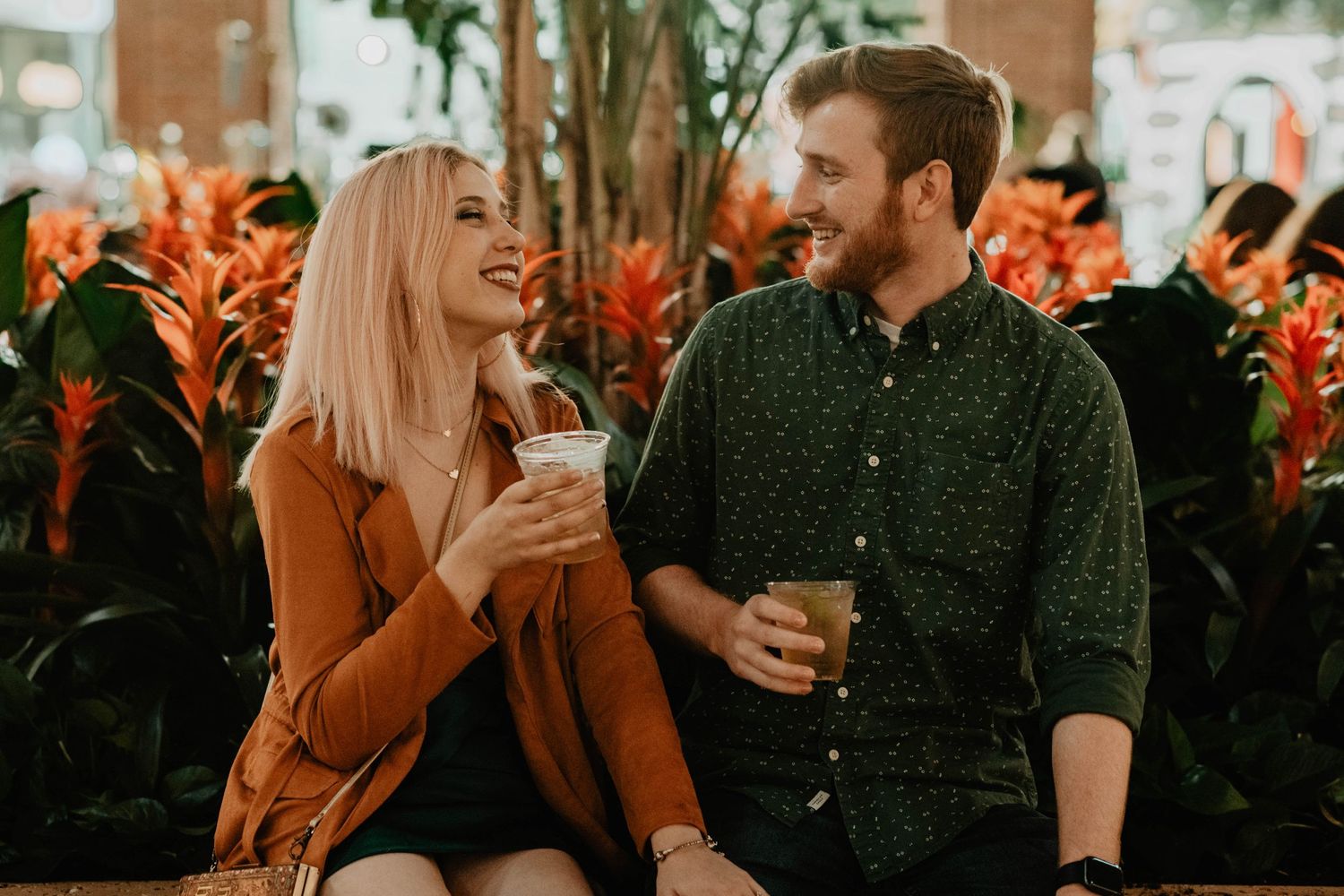 John & Emily anniversary photos at Disney Springs, candidly sipping drinks and laughing. Cred: LexTakePix