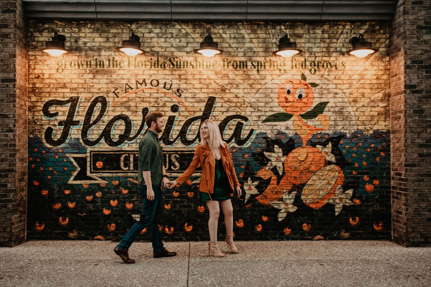 John & Emily anniversary photos at Disney Springs, in front of the Florida Citrus Orange Bird Mural. Cred: LexTakePix