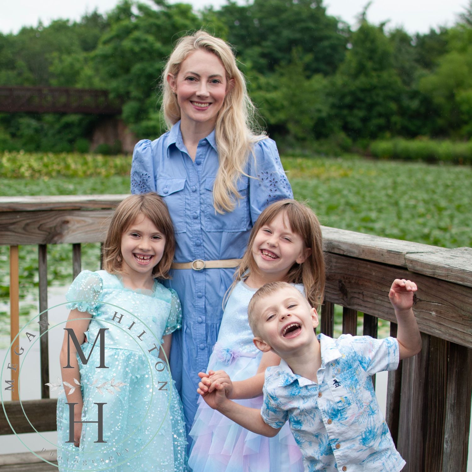 Family enjoying a candid moment together on wooden deck surrounded by lush green scenery in summer.