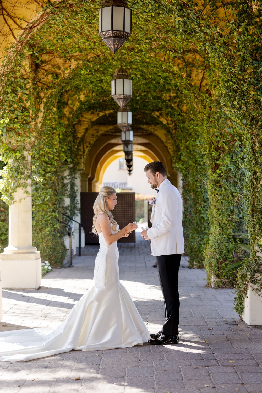 Wedding photos captured under an ivy-covered archway with romantic lighting.