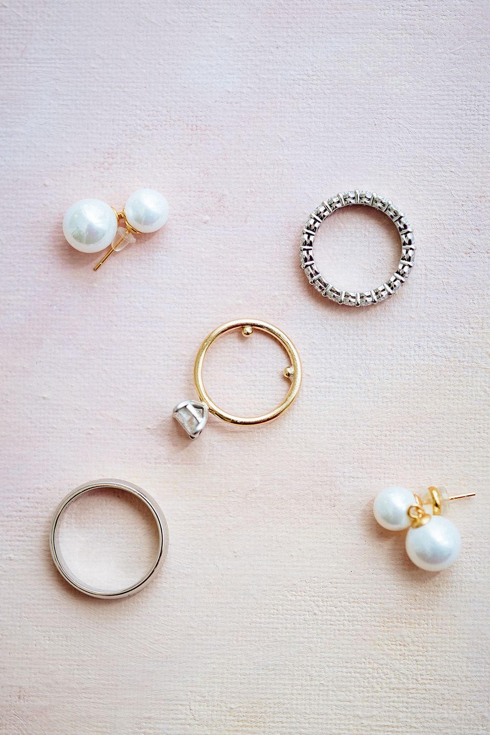 Tutorial showing step by step process of making a minimalist pearl and metal ring on white fabric background.