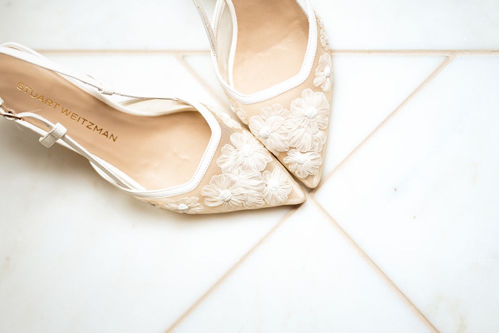 Elegant white lace bridal slingback heel shoe on a light background.