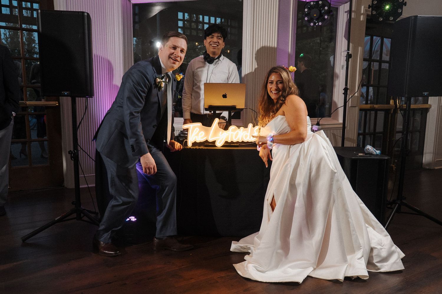 Couple dancing and enjoying intimate moments during their elegant wedding reception by candlelight and large windows.