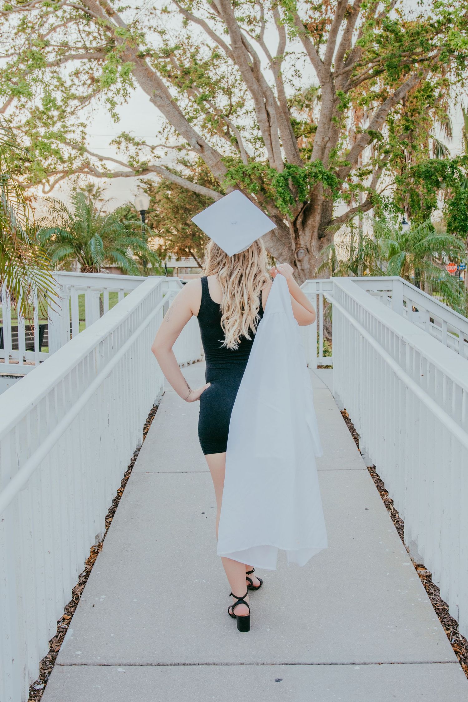 high school senior girl twirling in her prom dress at sunset.