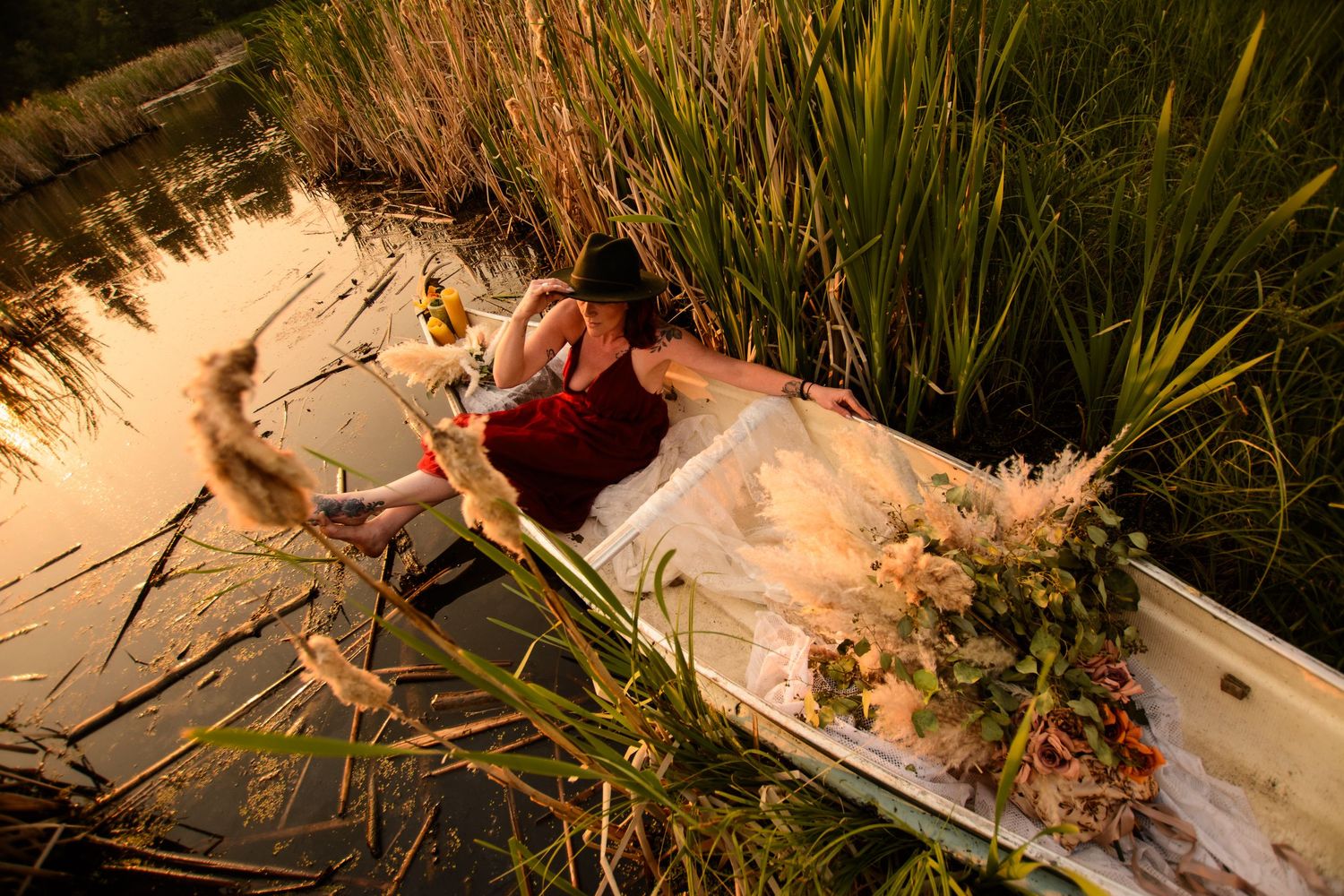 A white plastic straw or trash lays in green grass and vegetation along a shoreline or beach area.