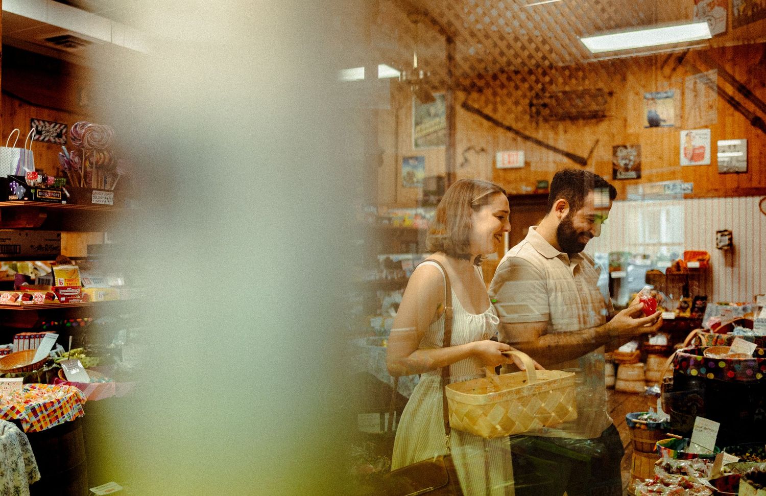 Two people shopping together in a cozy neighborhood grocery store with wooden walls and vintage decor.