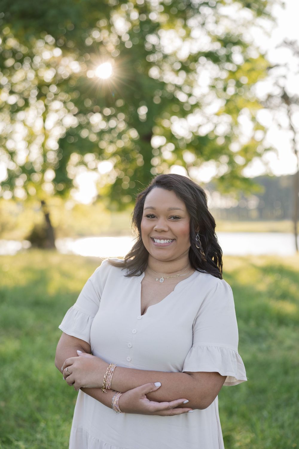 Four photos showing someone wearing a white dress posing outdoors during sunset in a grassy field area.
