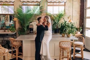 Light and airy wedding venue decorated with rattan furniture, natural sunlight, and tropical plants creates an elegant atmosphere.