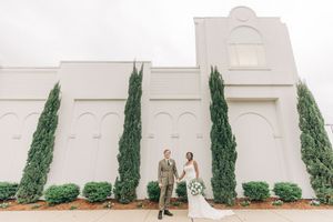 A series of matching photos showing a couple posing against a white wall with tall cypress trees.