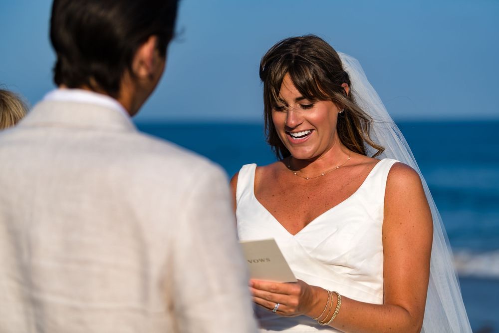 A couple shares an intimate moment by the ocean during a beach wedding ceremony.