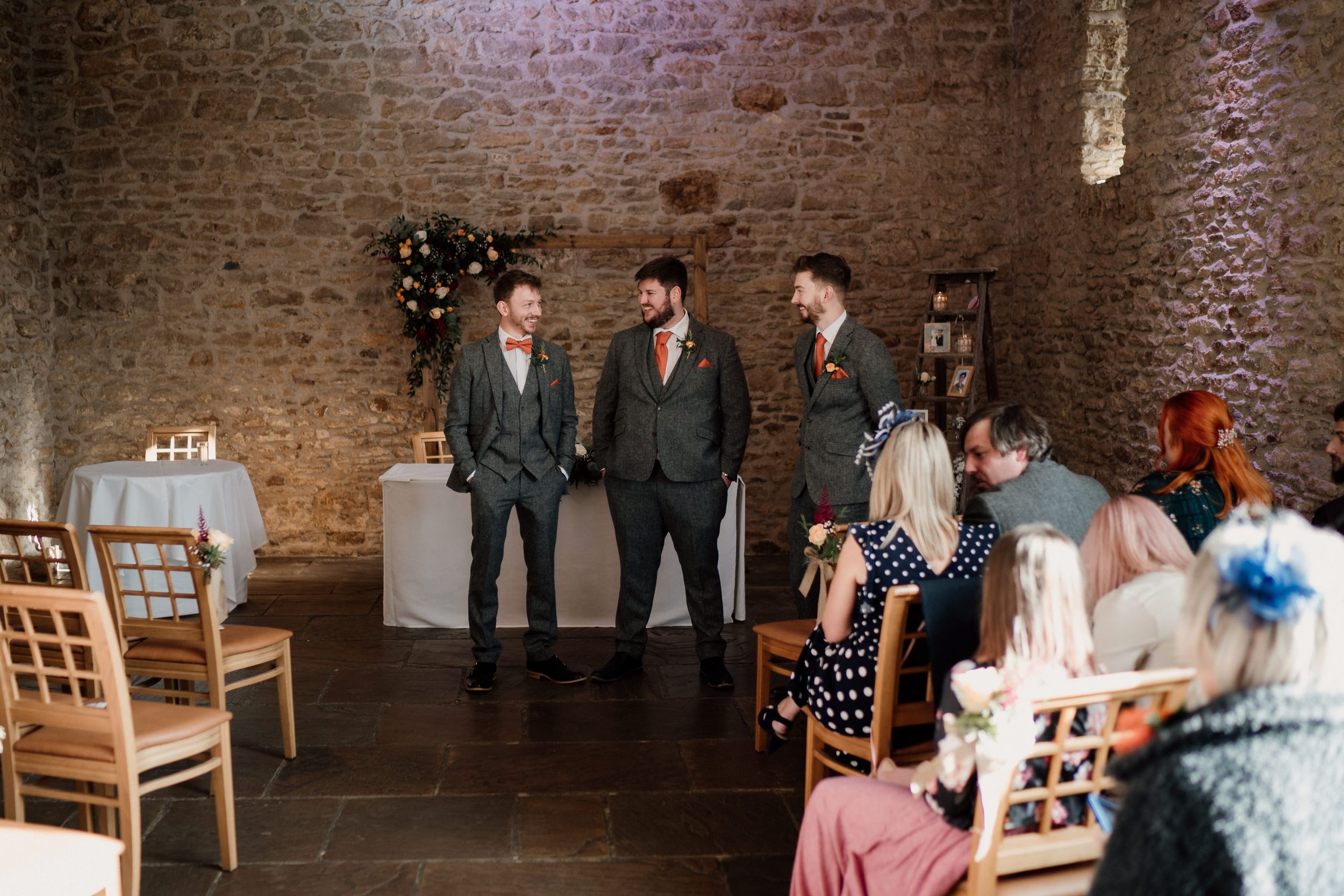 Wedding ceremony in a rustic Dodford Manor venue with exposed beams.