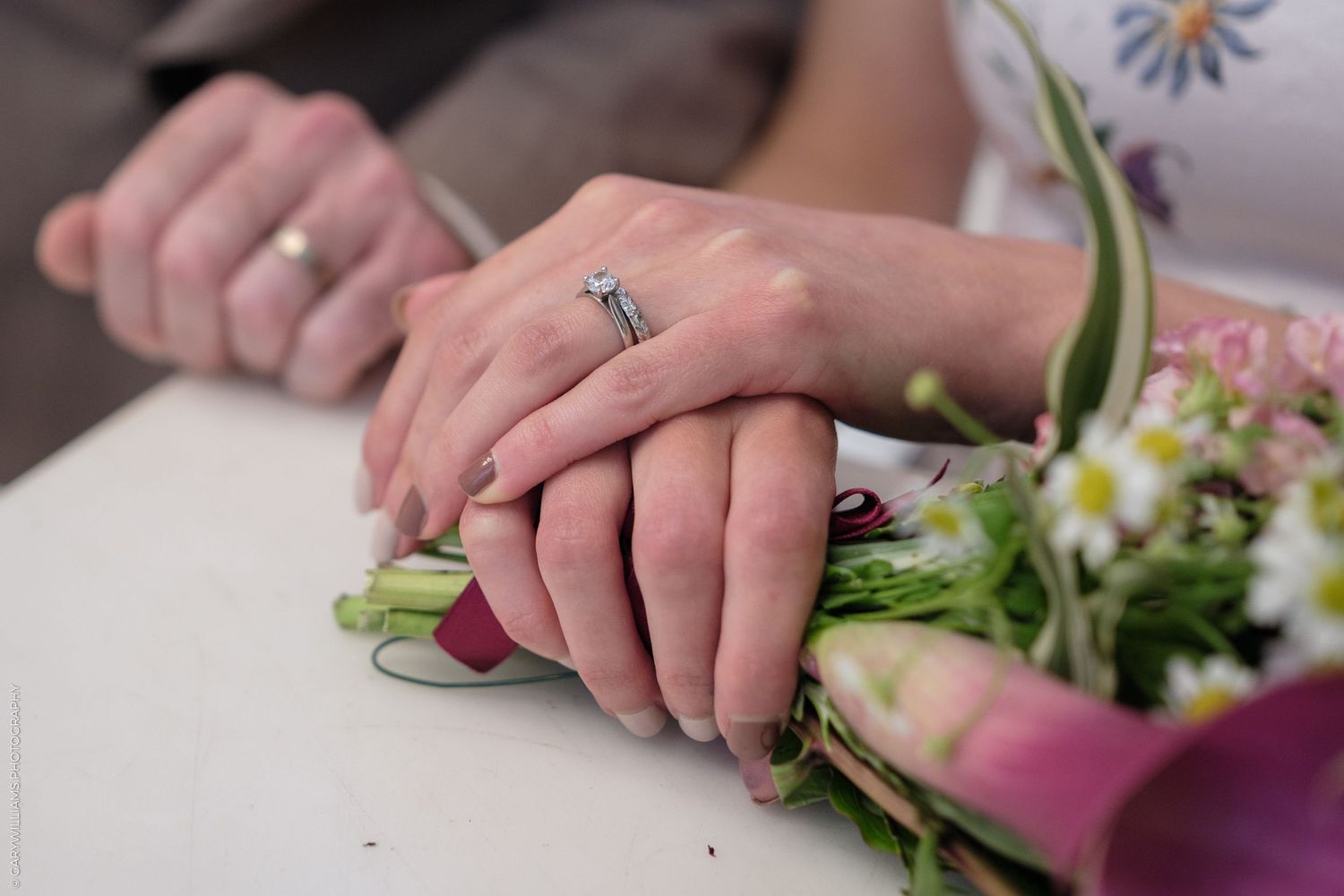 Hands preparing fresh string beans by snapping off the ends and cutting them into smaller pieces on a cutting board.