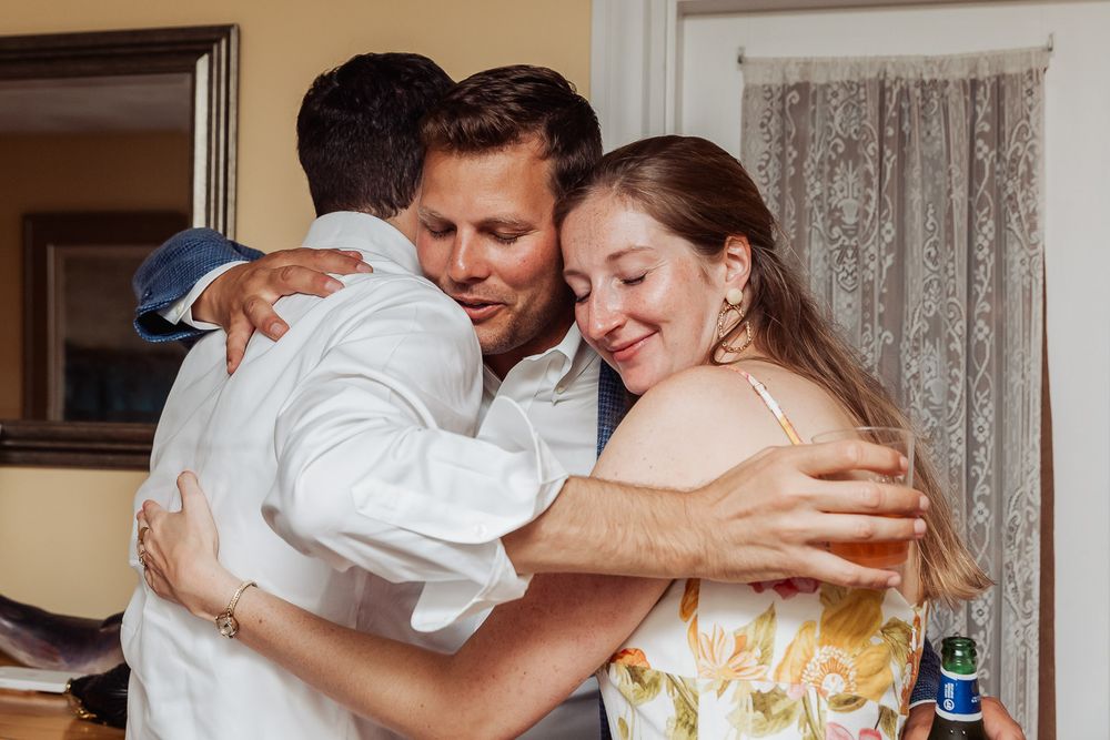Two people sharing a warm embrace at an indoor gathering.