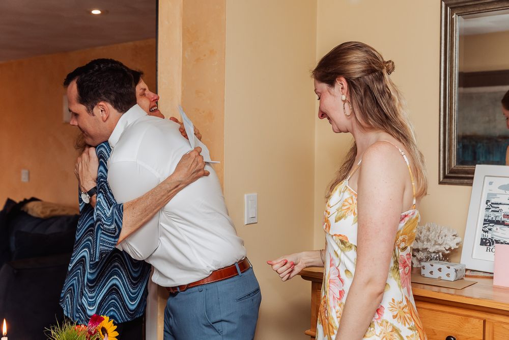 Group sharing hugs at an indoor celebration event.