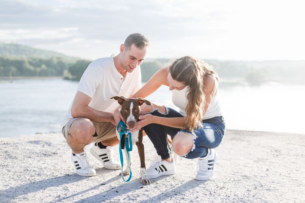 Family in coordinating white outfits playing together on a sunlit beach during a lifestyle photo session at sunset.