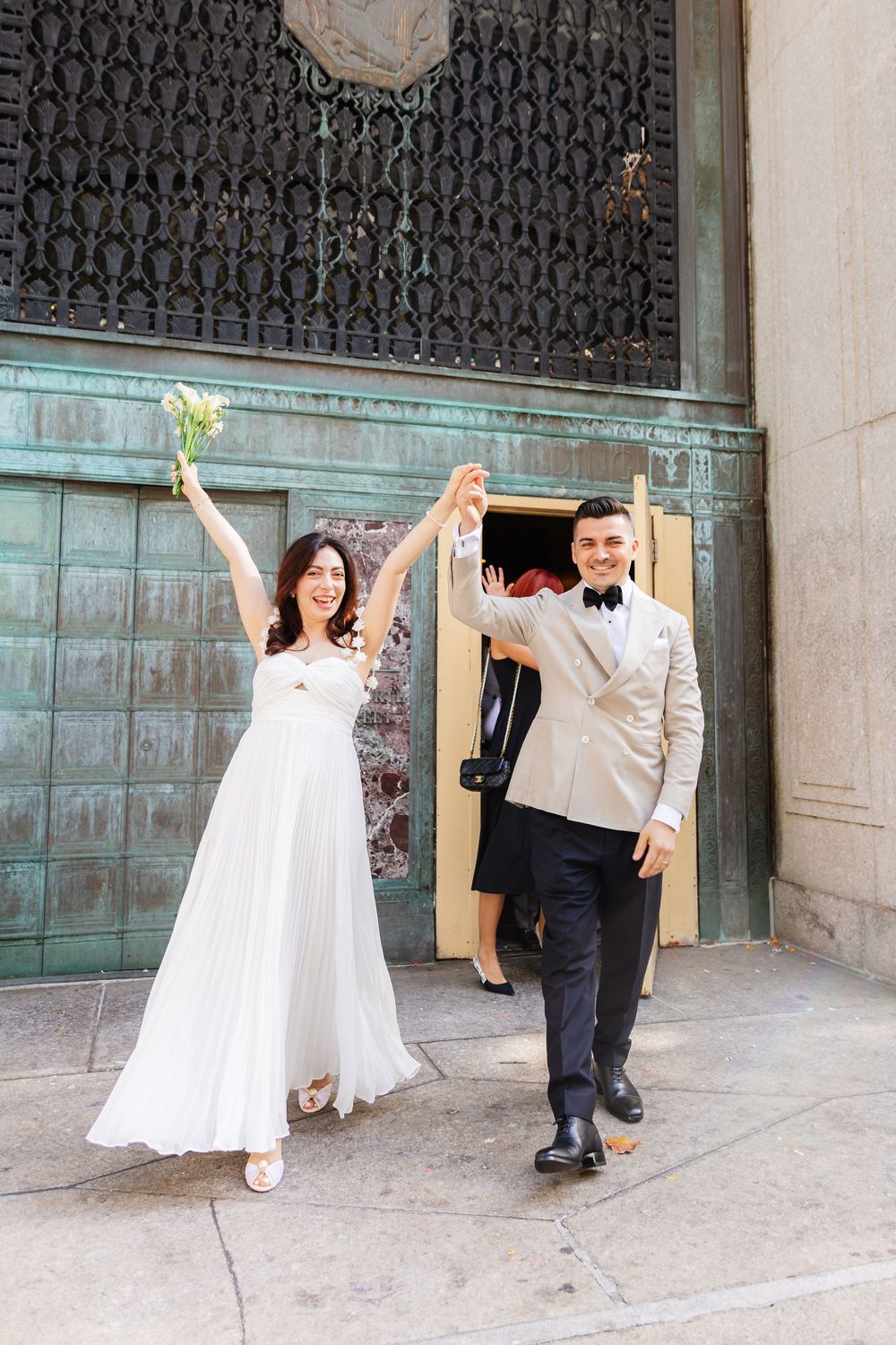 A sequence of five photos showing a wedding dress being held up against an industrial green door backdrop in an urban setting.