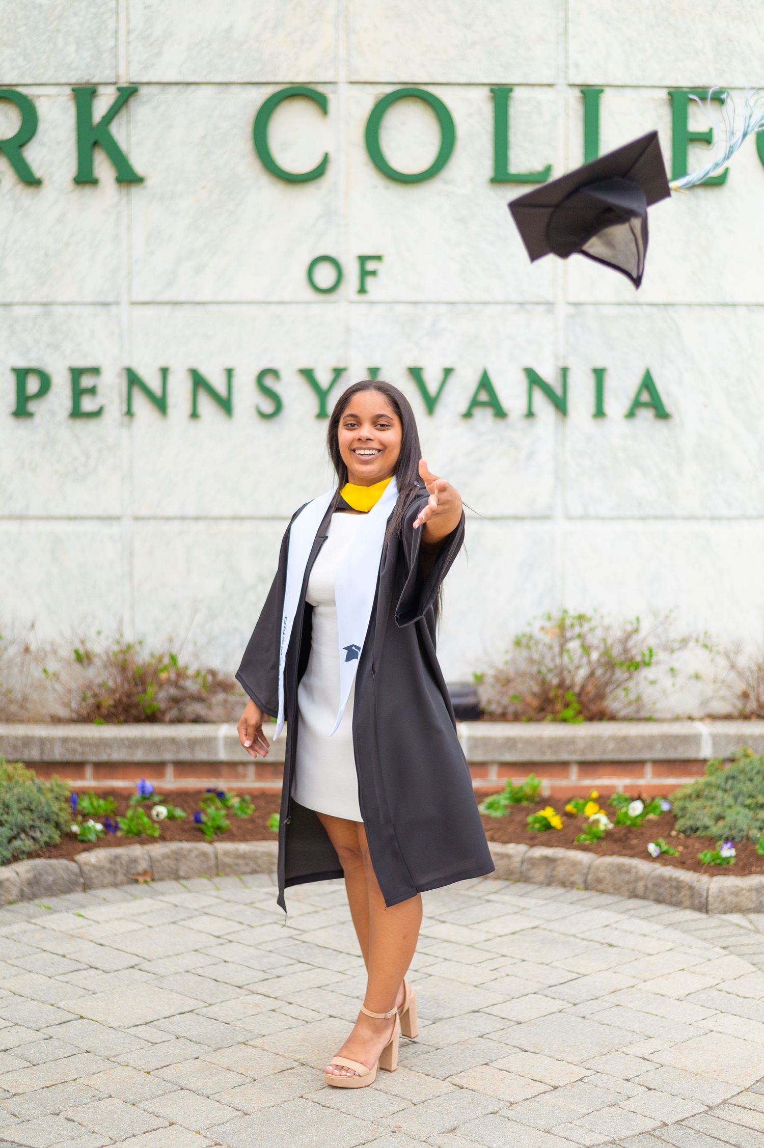 A celebratory graduation portrait at York College of Pennsylvania entrance.