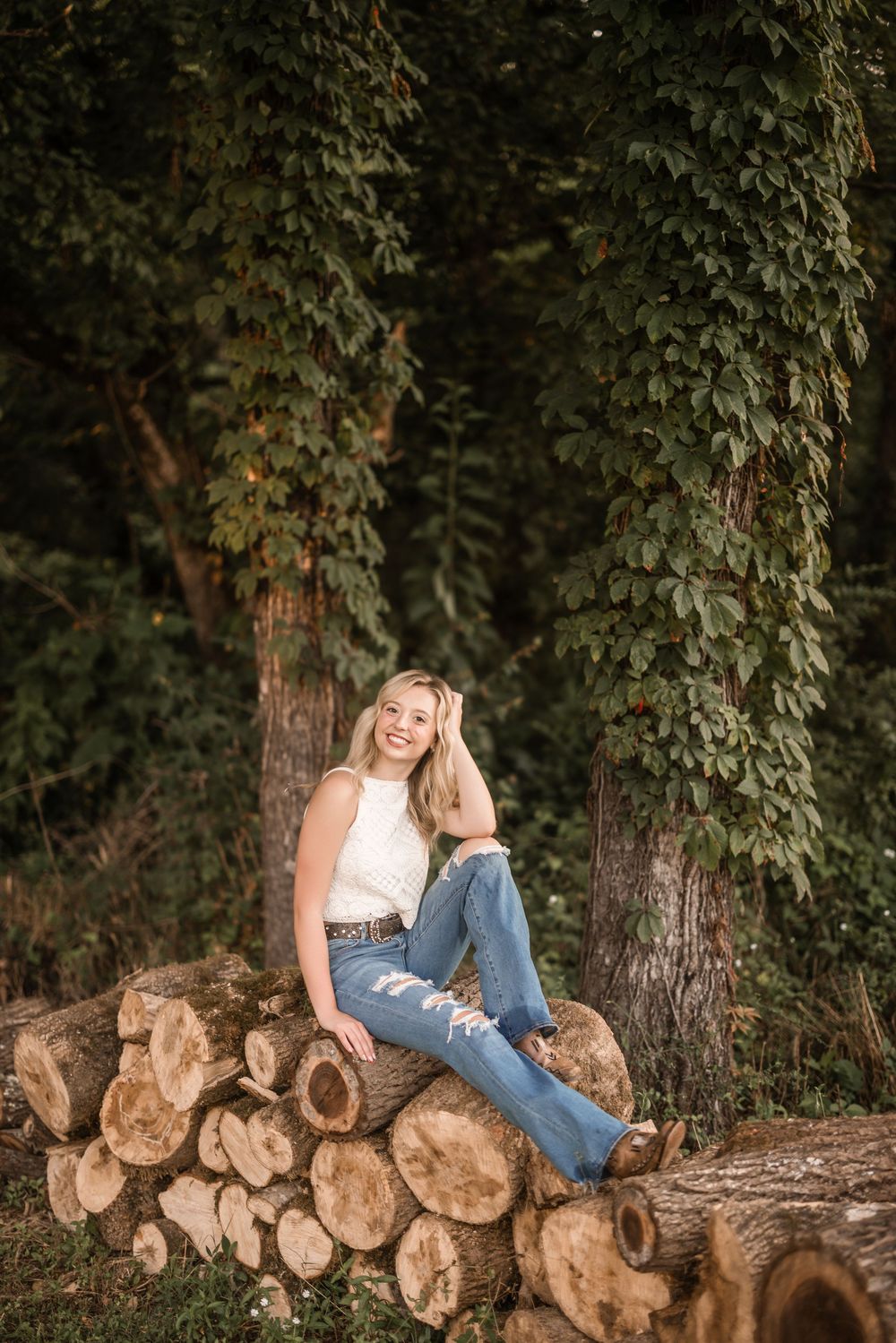 A sequence of artistic outdoor photos showing someone sitting on stacked logs against a backdrop of lush green foliage.