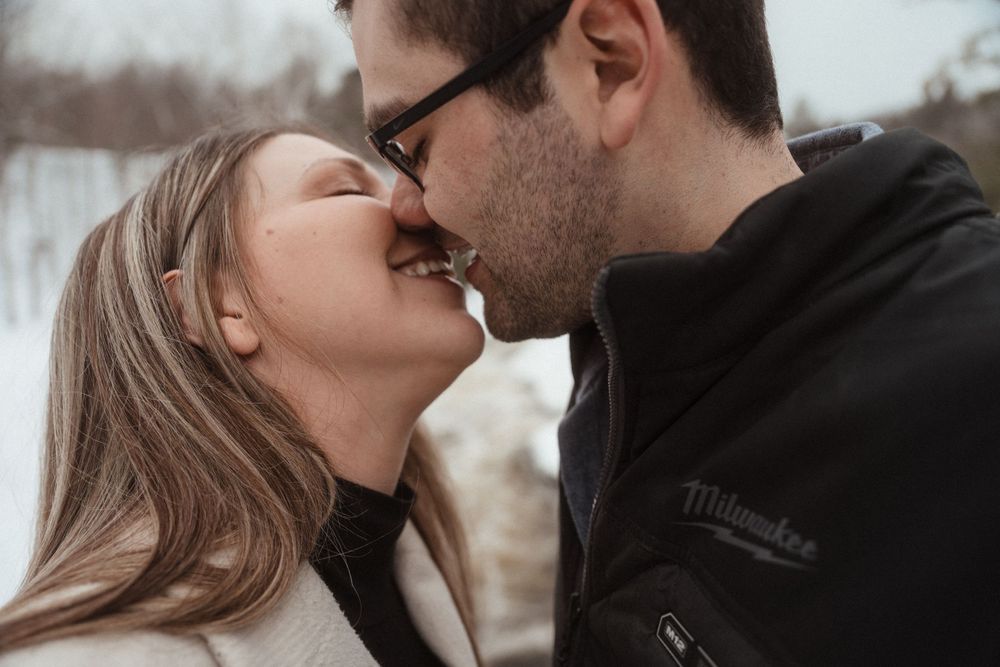 A romantic close-up of a couple sharing an intimate moment outdoors in winter.