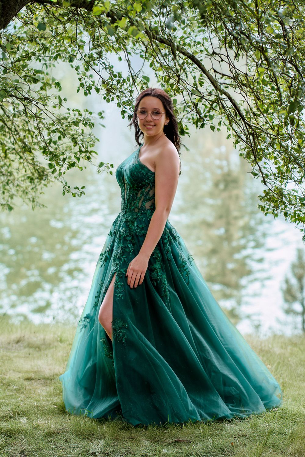 Portrait de finissante en robe verte, debout au bord d’un lac.
