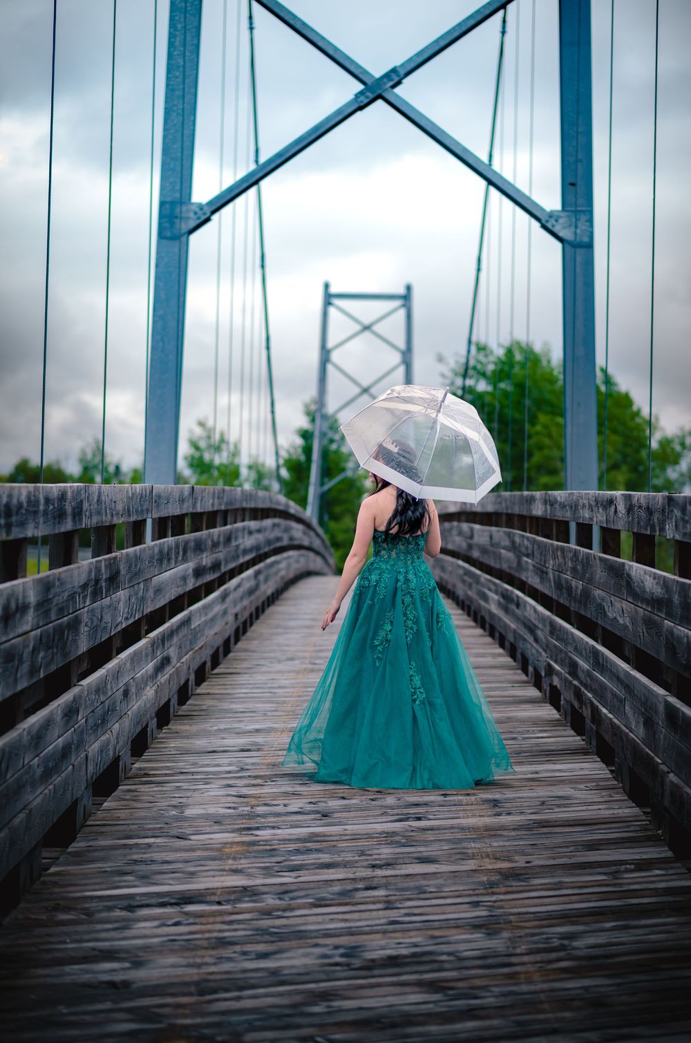 Fille en robe de finissante sous un parapluie, sur un pont