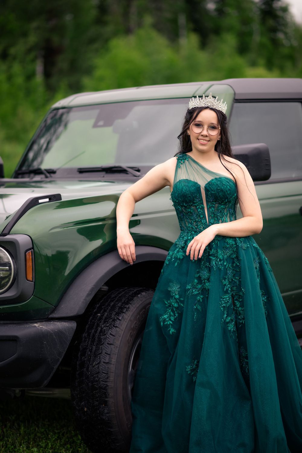Finissante souriante en robe de bal devant un jeep