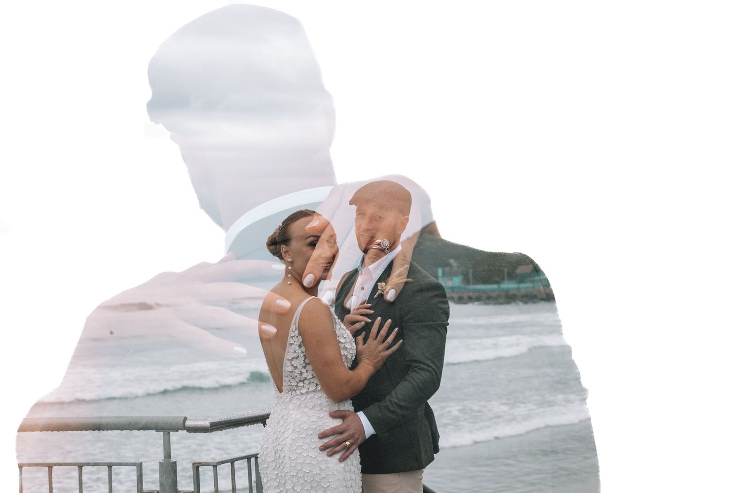 A romantic double exposure wedding portrait shows a couple embracing against a waterfront backdrop.