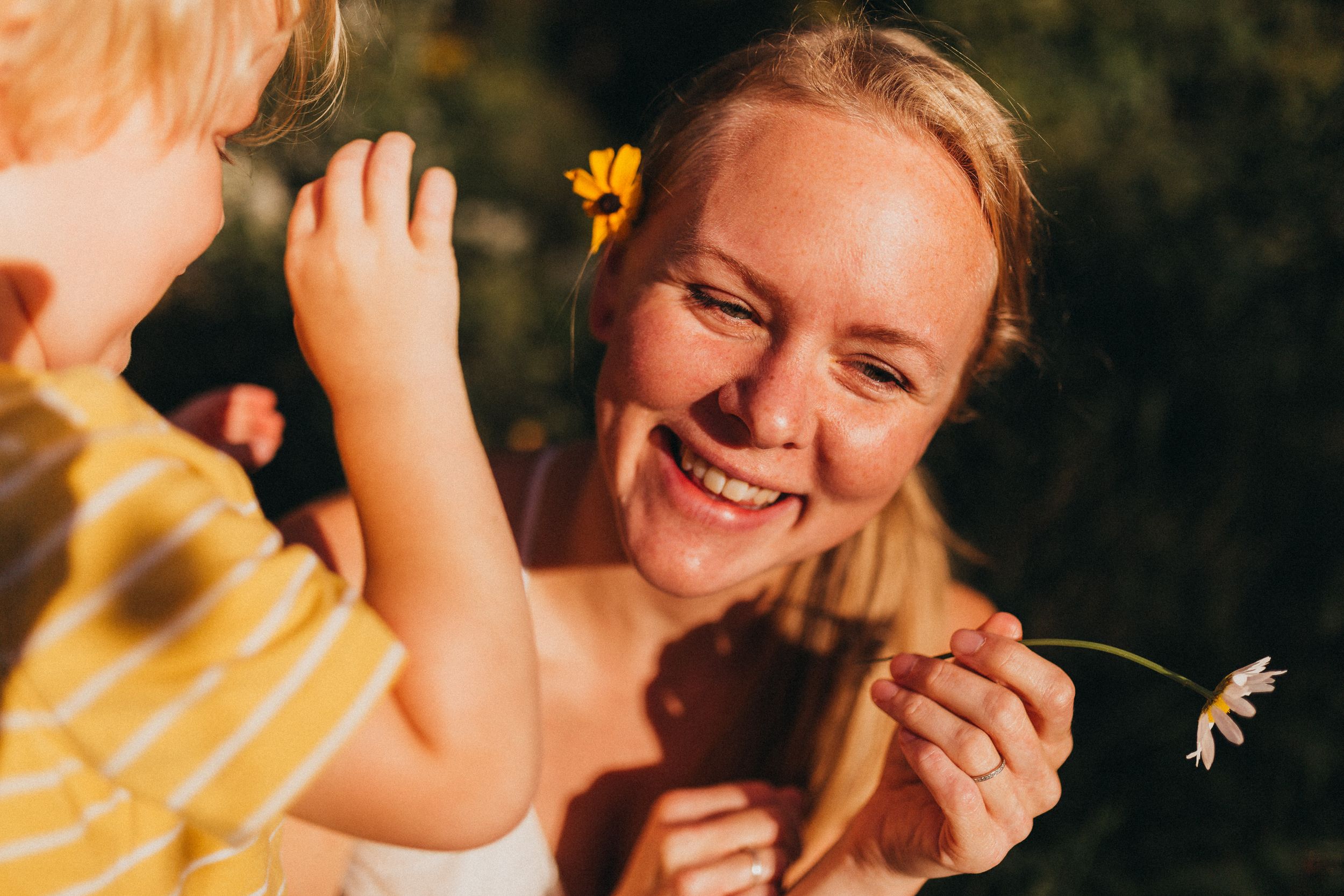 A joyful outdoor moment with flowers and sunshine creating a warm, golden atmosphere.