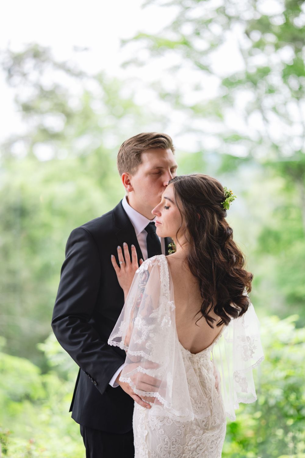 A romantic wedding couple shares three tender kisses in sequence against a soft green outdoor background.