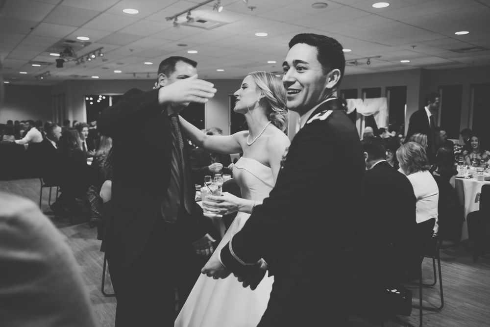People enjoying themselves and dancing together in a lively celebration at an indoor reception venue.