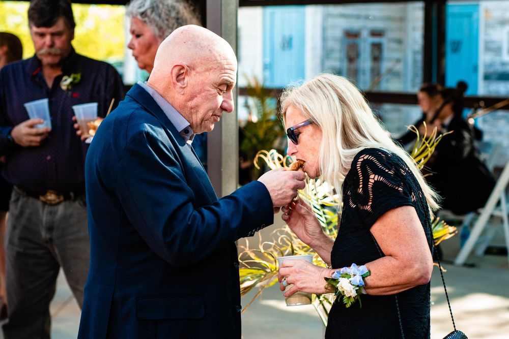 Elegant outdoor wedding reception moment with dancing couples and floral arrangements.