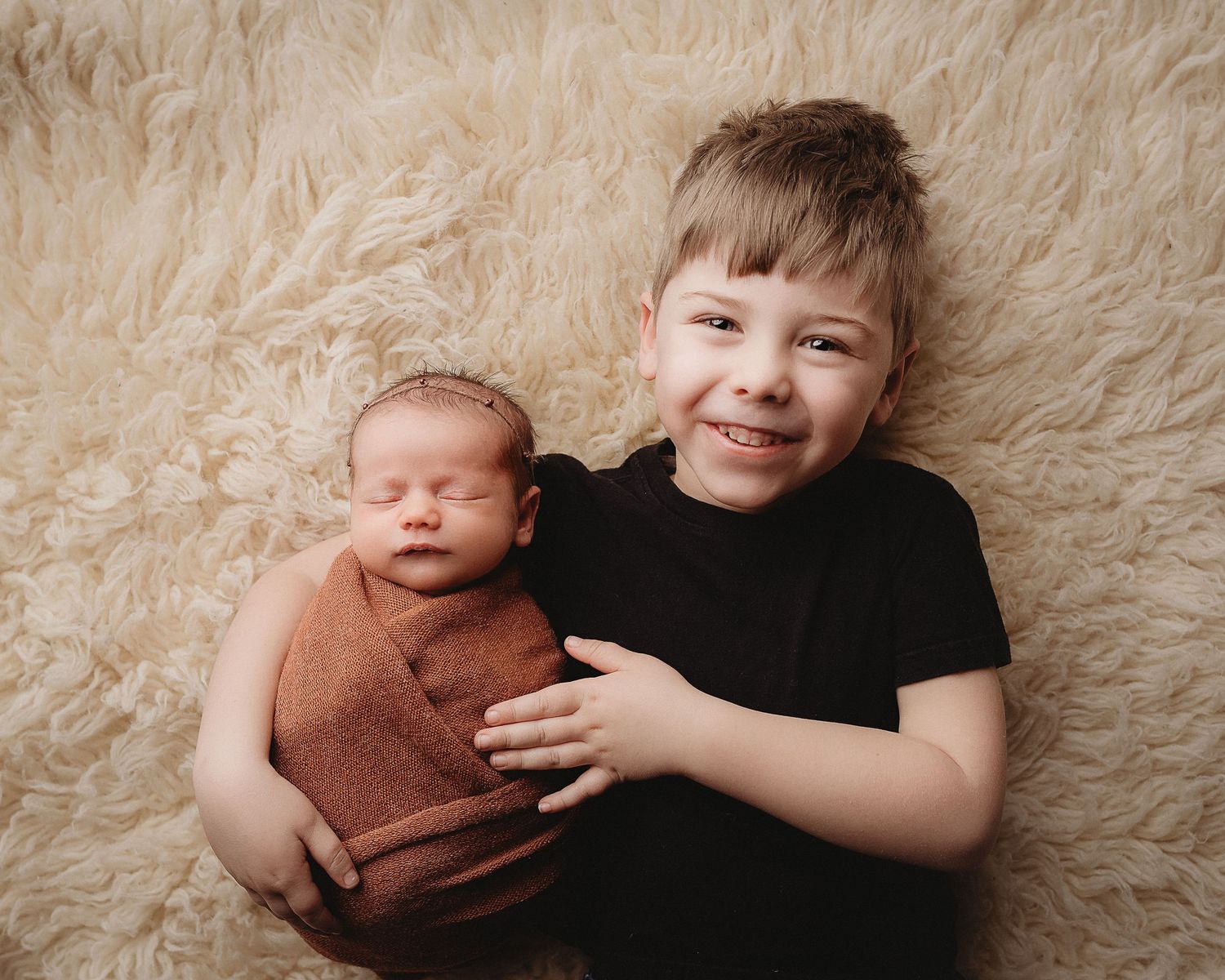 Professional newborn photo of a baby and his big brother