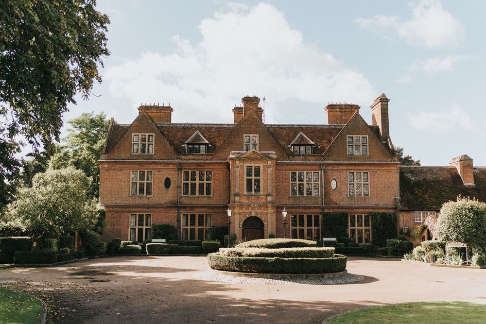 Brick manor house panorama showing elegant architecture and landscaped grounds in changing light conditions.
