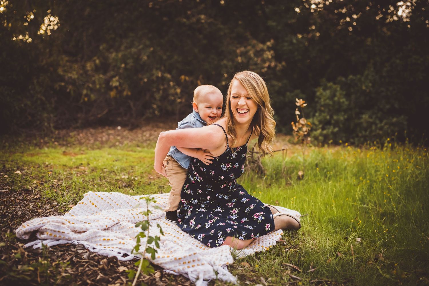 Candid moment captured on a white blanket in a sunlit meadow during a summer evening.